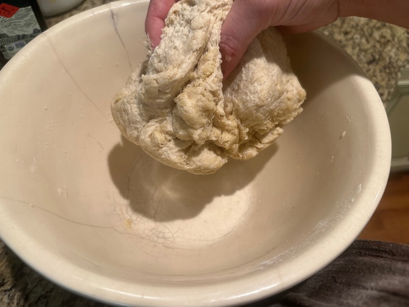 hand holding combined pizza dough