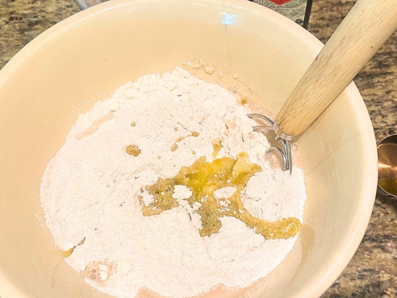 in process image of dry and wet ingredients being combined in a bowl