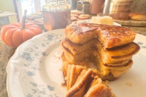 stack of pumpkin pancakes on a place sliced into