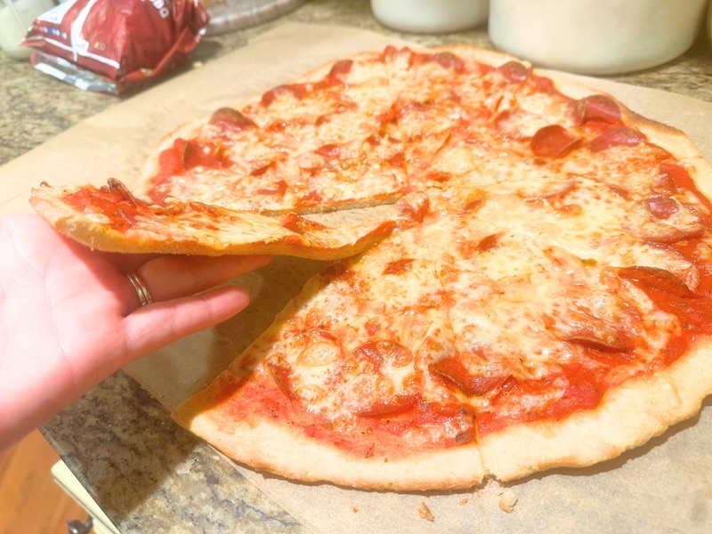 hand holding a slice of easy homemade pizza